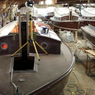 Eine Bootsbau-Halle mit einem Segelboot, an dem gerade gearbeitet wird.